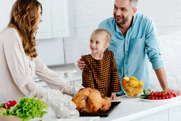 Criança pequena feliz preparando o jantar de ação de graças com os pais — Fotografia de Stock