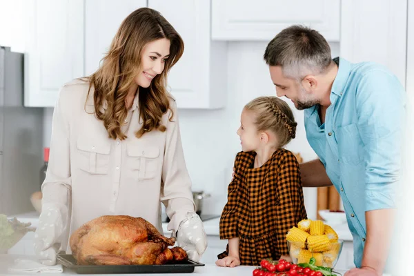 Adorable niño pequeño preparando cena de acción de gracias con los padres - foto de stock