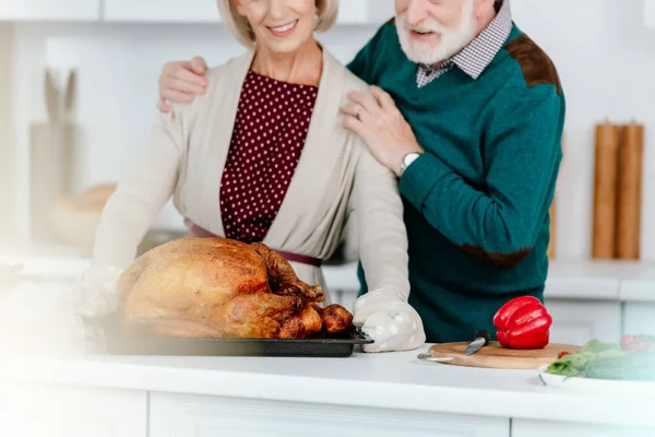 Plan recadré de couple senior cuisine dinde thanksgiving ensemble — Photo de stock