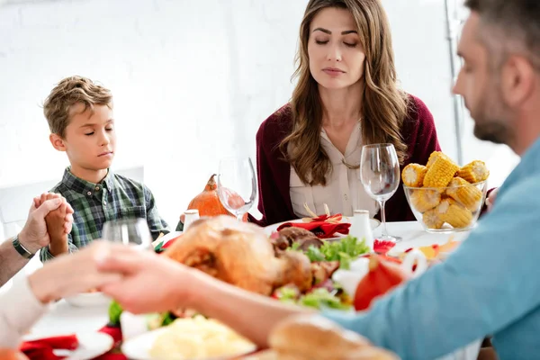 Family praying at served table with turkey before holiday dinner on thanksgiving — Stock Photo