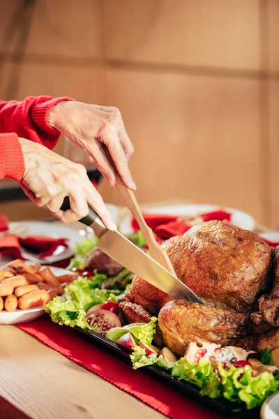 Imagen recortada de la mujer en rodajas vacaciones delicioso pavo en la mesa - foto de stock