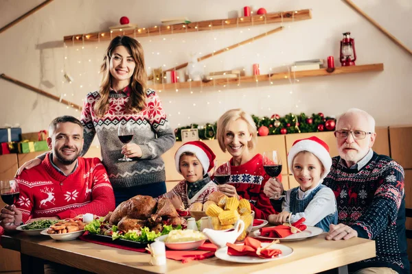 Feliz gran familia con niños celebrando la Navidad con vino en casa - foto de stock