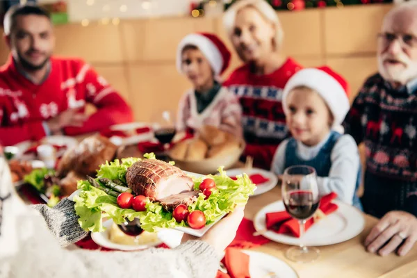 Visão parcial da mulher que transporta refeição para o jantar de Natal com a família em casa — Fotografia de Stock