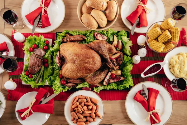 Vista elevada de la mesa servida con deliciosos platos y vino para la cena de vacaciones en Acción de Gracias - foto de stock