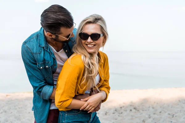Namorado abraçando namorada feliz na praia — Fotografia de Stock