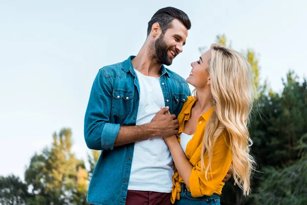 Happy couple holding hands and looking at each other in park — Stock Photo