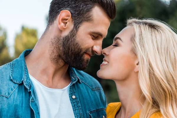 Porträt eines glücklichen Paares, das sich im Park mit der Nase berührt — Stockfoto