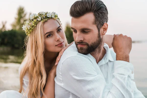 Portrait of beautiful bride in wreath and handsome groom on beach — Stock Photo