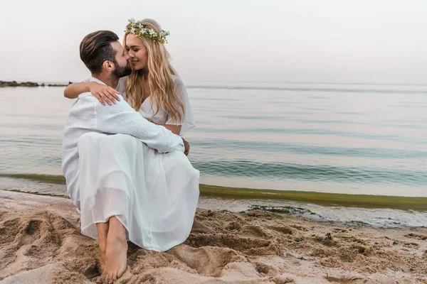 Affectionate bride and groom going to kiss on beach — Stock Photo