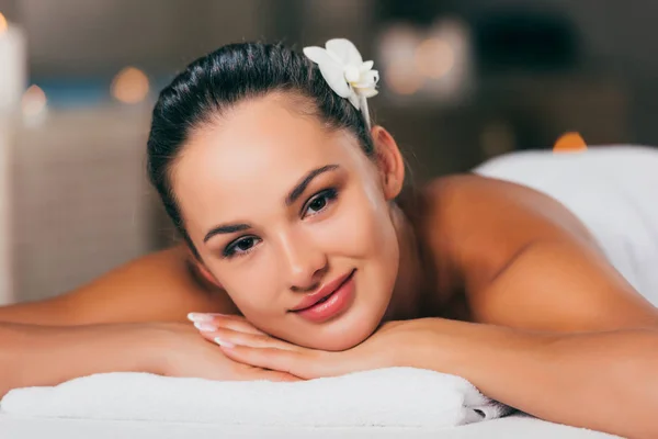 Mujer feliz relajarse en el salón de spa y mirando a la cámara - foto de stock