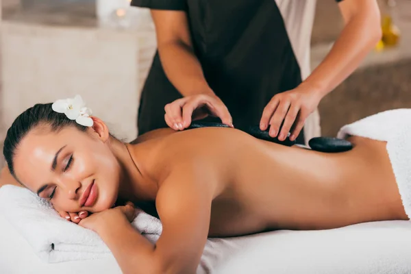 Smiling young woman having stone therapy at spa salon — Stock Photo