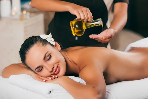 Mujer relajante teniendo terapia de masaje con aceite corporal - foto de stock