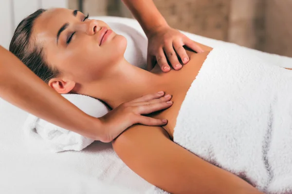 Atractiva mujer teniendo masaje en el salón de spa - foto de stock