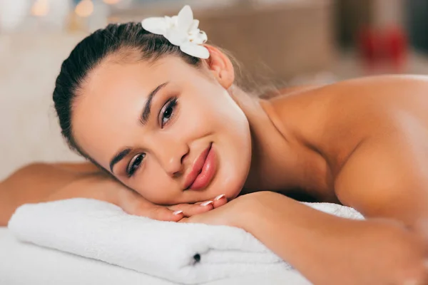 Frau mit weißer Blume im Haar entspannt im Wellness-Salon — Stockfoto