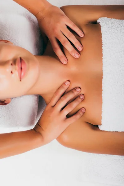 Relaxing young woman having shoulders massage at spa salon — Stock Photo