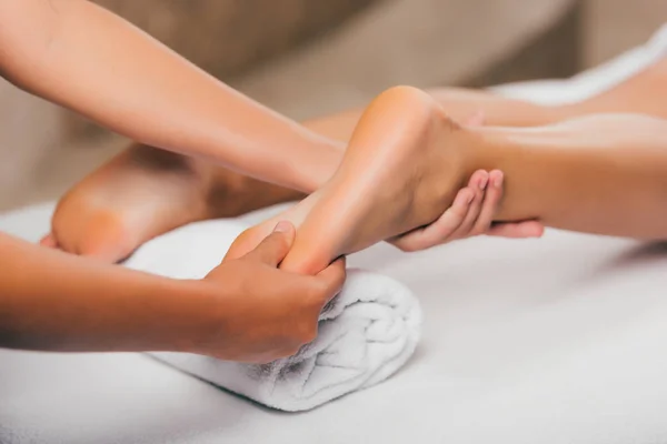 Vue recadrée de la femme relaxante et ayant massage des pieds dans le salon de spa — Photo de stock