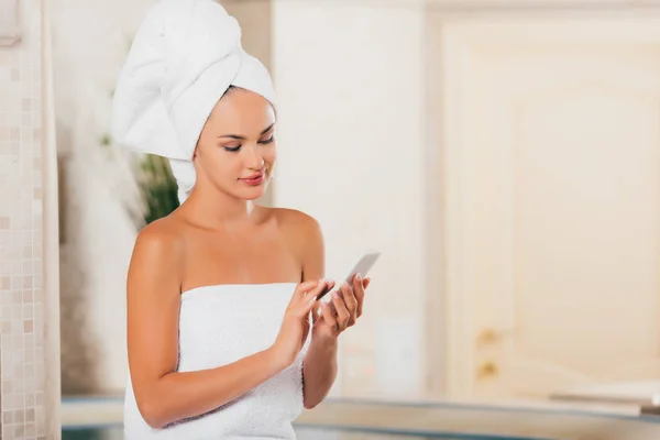 Donna attraente utilizzando gadget al salone spa — Foto stock