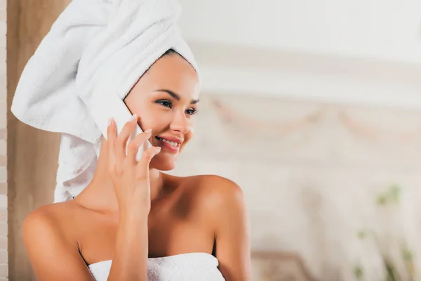 Smiling woman talking on smartphone at spa salon — Stock Photo