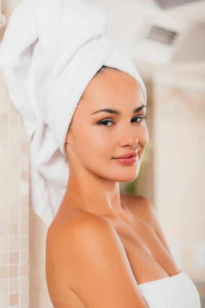 Jeune femme souriante relaxant avec serviette sur la tête — Photo de stock