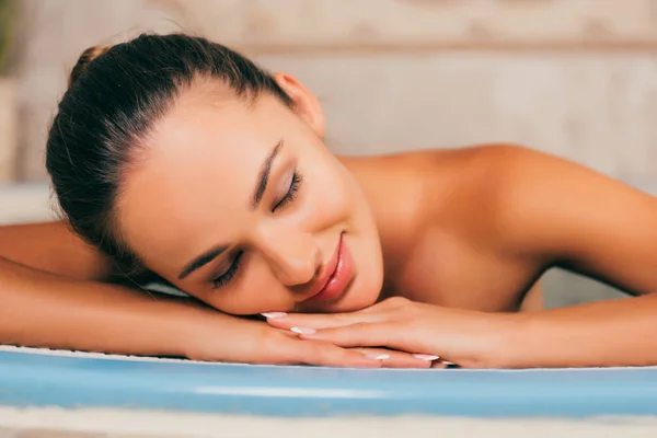 Mujer relajante con los ojos cerrados en el salón de spa - foto de stock