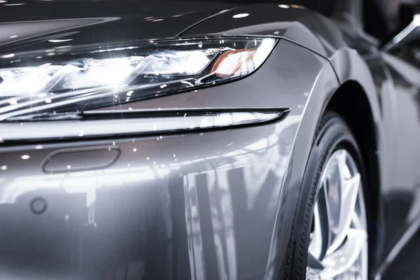 Vista de cerca del coche brillante de lujo en el salón de automóviles - foto de stock