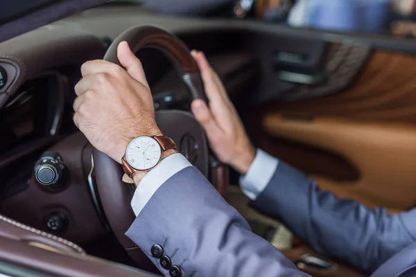 Recortado disparo de hombre de negocios sentado en coche nuevo para la prueba de conducción en salón de concesionarios - foto de stock