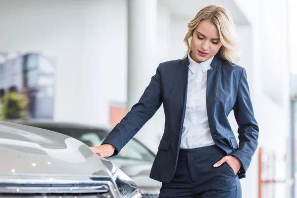 Porträt einer stilvollen Geschäftsfrau im Anzug bei der Wahl des Autos im Autohaus-Salon — Stockfoto