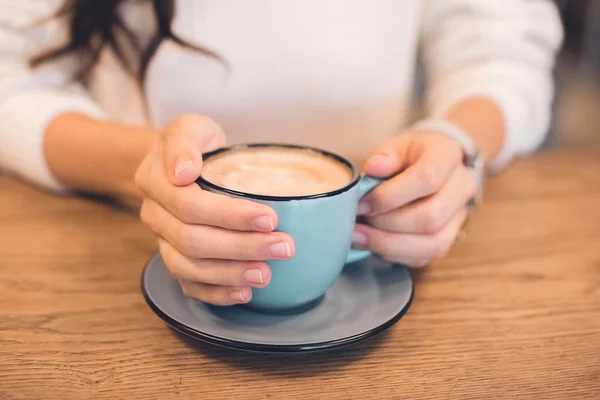 Imagem cortada de mulher sentada com xícara de café à mesa no café — Fotografia de Stock