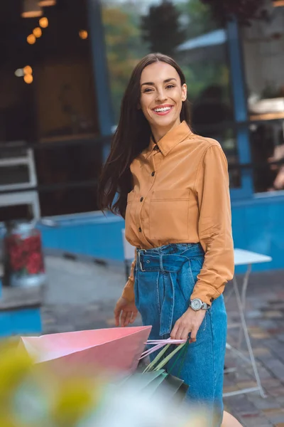 Glücklich stylische junge Frau läuft mit Einkaufstüten auf der Stadtstraße — Stockfoto