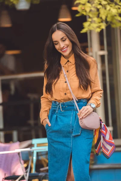 Happy fashionable young woman with stylish handbag at urban street — Stock Photo