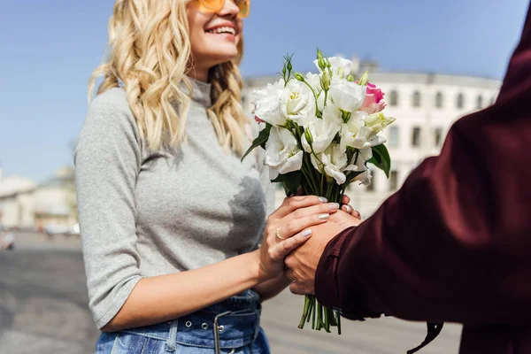 Recortado imagen de novio presentando ramo a novia en la calle - foto de stock