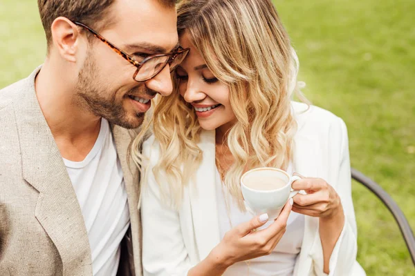 Coppia affettuosa in abito autunnale seduto nel caffè, fidanzata con in mano una tazza di caffè — Foto stock