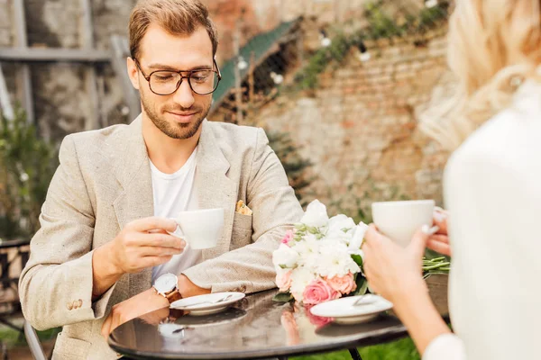 Image recadrée de couple en tenue d'automne assis à table dans un café — Photo de stock