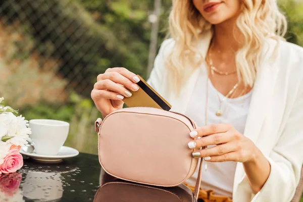Immagine ritagliata della donna che prende la carta di credito dalla borsa in caffè — Foto stock
