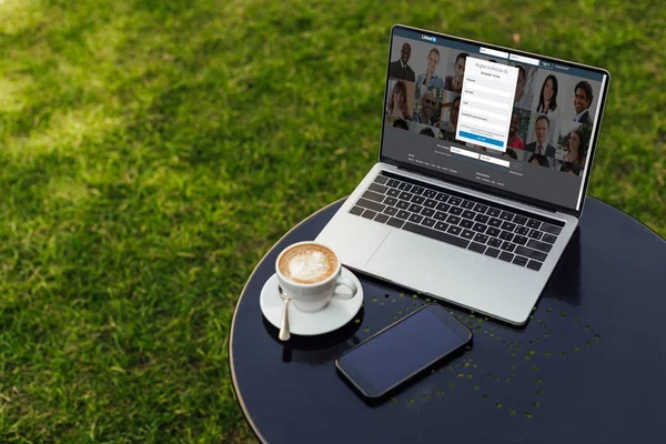 Laptop with loaded linkedin page on table in garden — Stock Photo