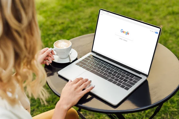 Abgeschnittenes Bild einer Frau mit Laptop und geladener Google-Seite auf Tisch im Garten — Stockfoto