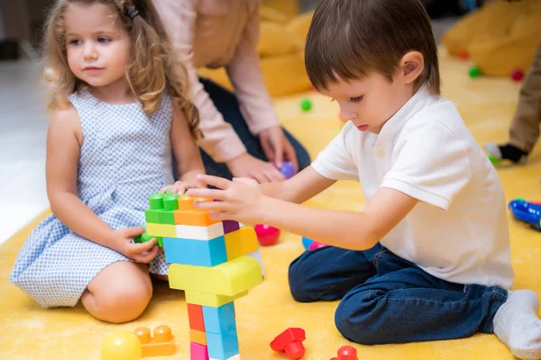 Adorables enfants jouant avec le constructeur à la maternelle — Photo de stock