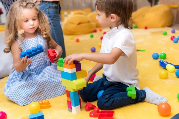 Adorables enfants jouant avec le constructeur à la maternelle — Photo de stock