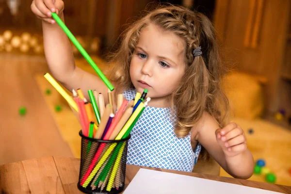 Adorable child taking green felt tip pen for drawing in kindergarten — Stock Photo