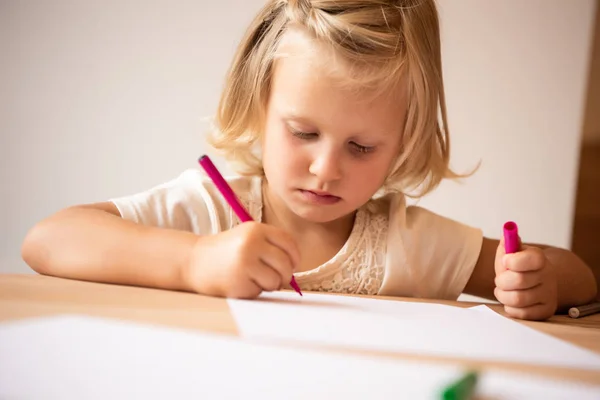 Seria adorable niño dibujo con rosa fieltro pluma en el jardín de infantes - foto de stock