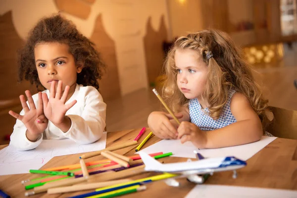 African american kid showing number nine with fingers in kindergarten — Stock Photo