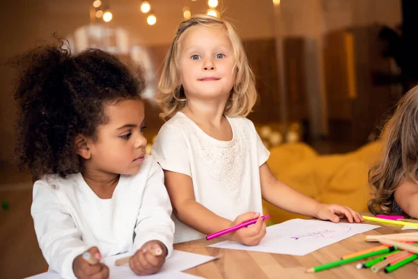 Adorable multicultural children drawing together in kindergarten — Stock Photo