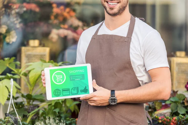 Обрізане зображення усміхненого флориста, що тримає планшет з торговим приладом біля квіткового магазину — стокове фото