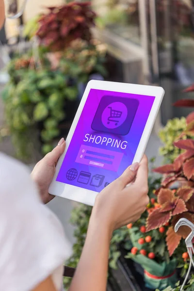 Cropped image of florist holding tablet with shopping appliance near flower shop — Stock Photo