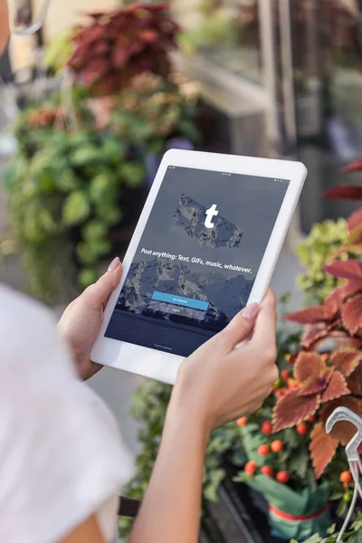 Cropped image of florist using tablet with loaded tumblr page near flower shop — Stock Photo