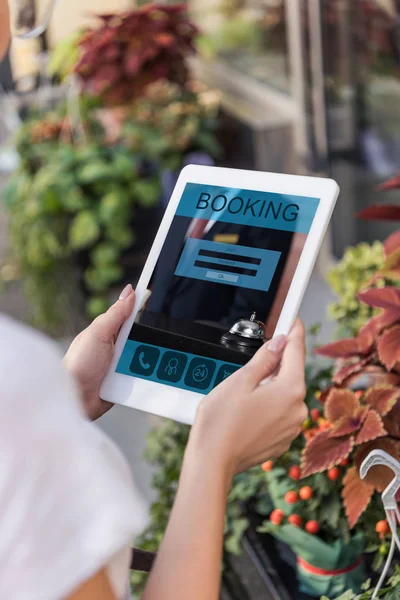 Cropped image of florist holding tablet with booking website near flower shop — Stock Photo