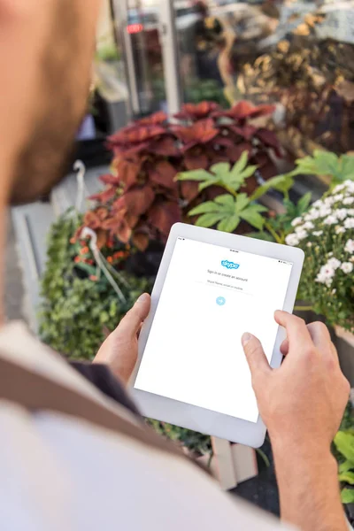 Cropped image of florist using tablet with loaded skype page near flower shop — Stock Photo