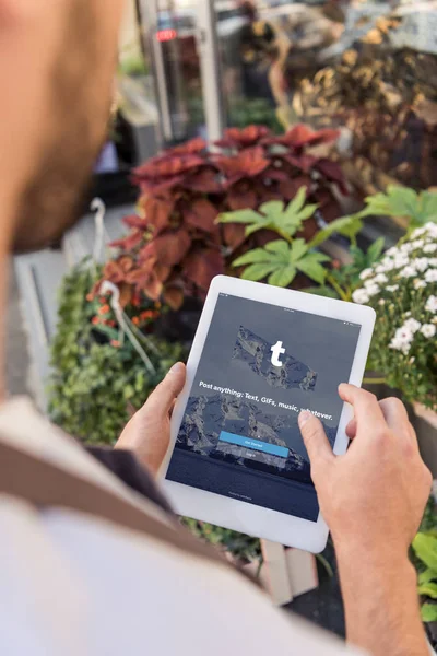 Image recadrée de fleuriste à l'aide d'une tablette avec la page tumblr chargé près de magasin de fleurs — Photo de stock