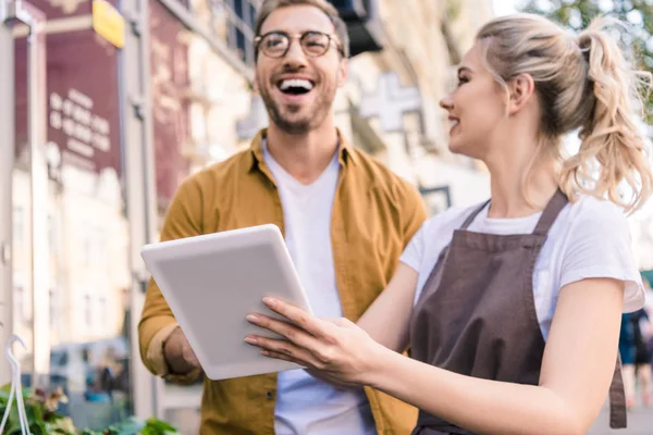 Fiorista ridere e cliente utilizzando tablet al negozio di fiori — Foto stock