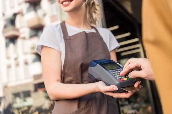 Cropped image of customer paying with credit card at flower shop and entering pin code — Stock Photo